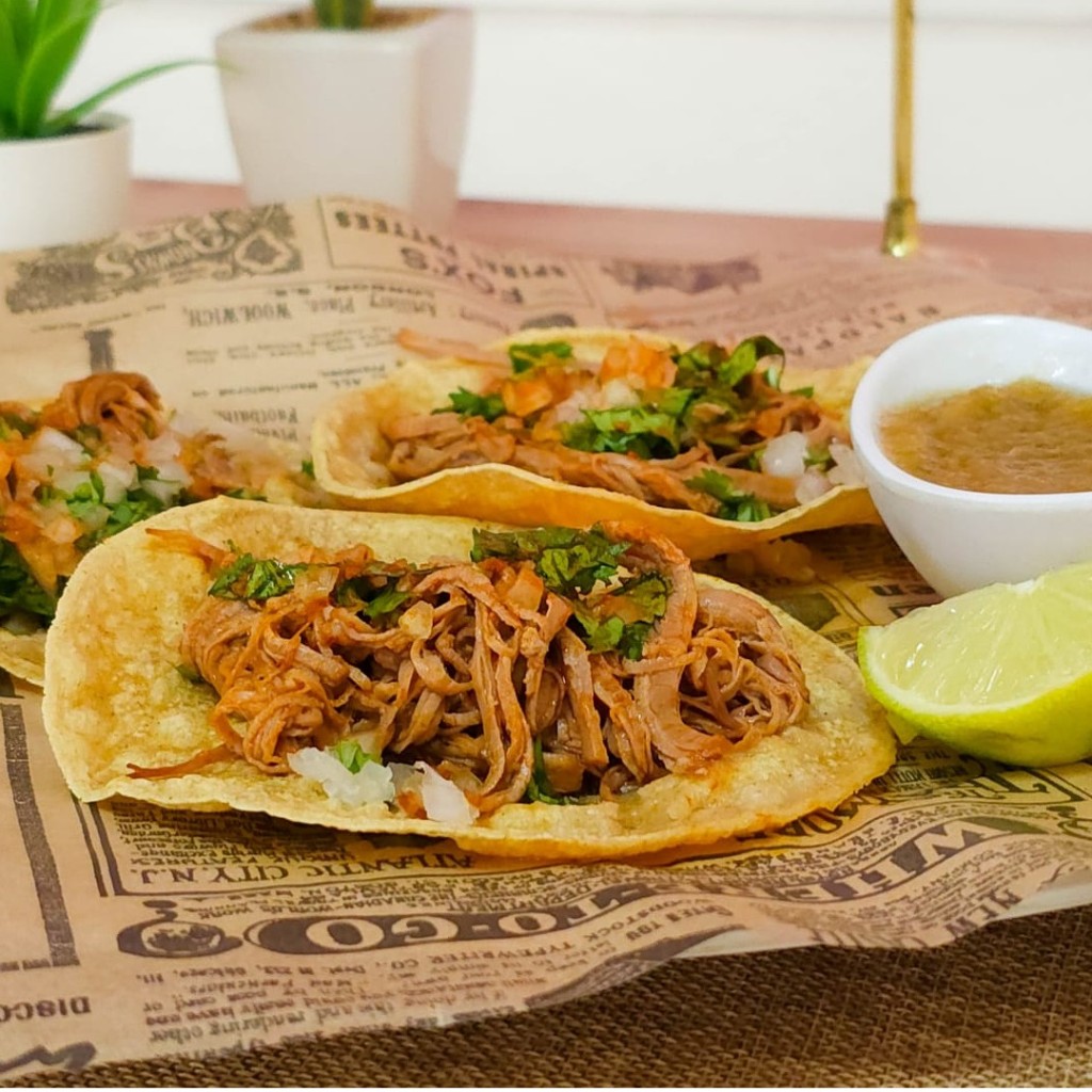 Tacos de birria de res con cilantro, salsa y lima